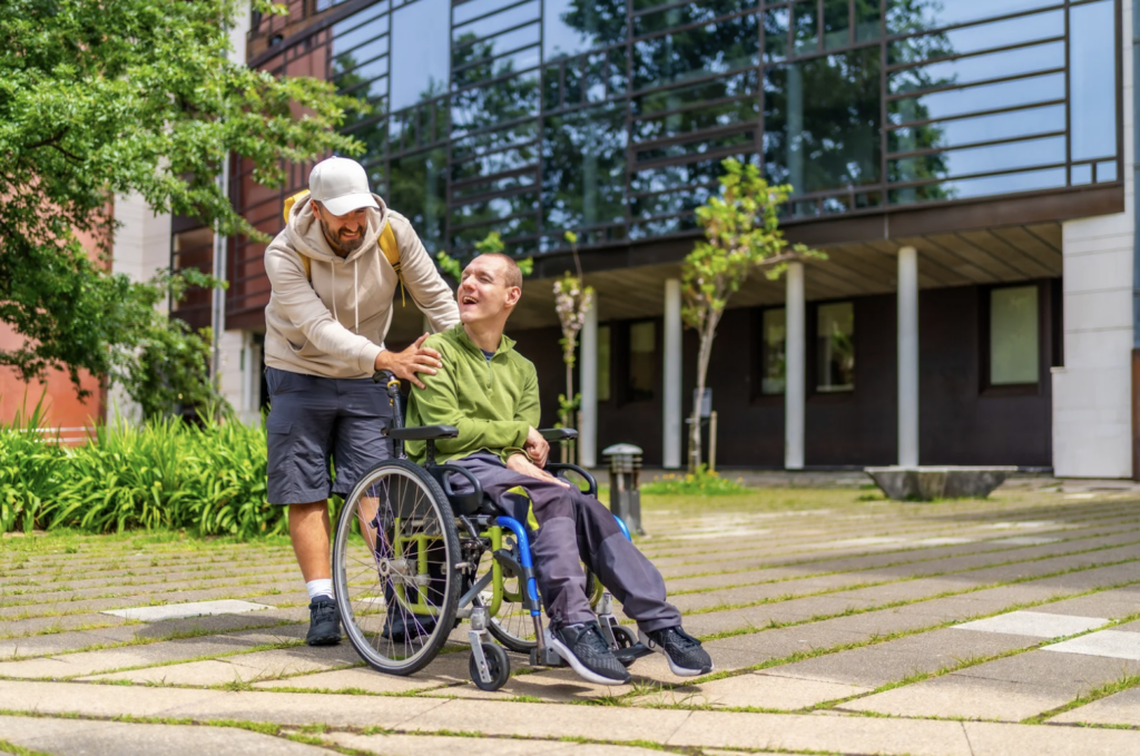 Caregiver supporting an adult with special needs in a wheelchair outside a residential facility in California, symbolizing compassionate planning for the future.
